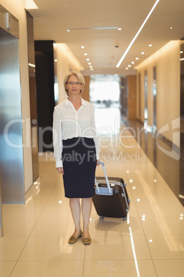 Portrait of businesswoman with suitcase