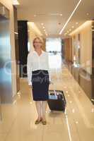 Portrait of businesswoman with suitcase