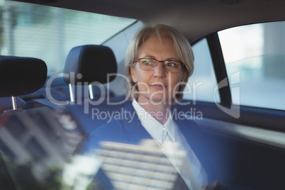 Thoughtful businesswoman traveling in car