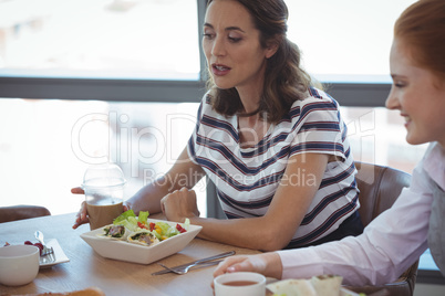 Female business colleagues having breakfast at office cafeteria