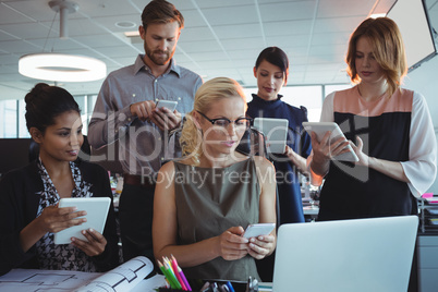 Business colleagues using mobile phones and digital tablets together