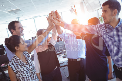 Happy business colleagues putting their hands together