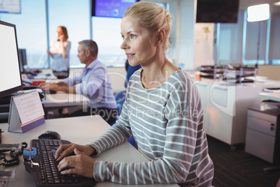 Concentrated businesswoman typing on keyboard at office