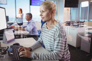 Concentrated businesswoman typing on keyboard at office