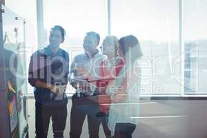 Happy business entrepreneurs looking at whiteboard seen through glass