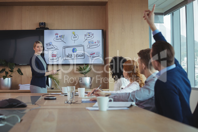 Businesswoman interacting with team during meeting in boatd room