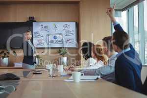 Businesswoman interacting with team during meeting in boatd room