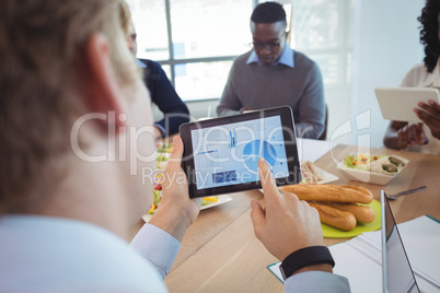 Businessman using digital tablet at breakfast table