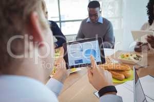 Businessman using digital tablet at breakfast table