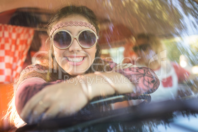 Smiling woman in camper van seen through windshield