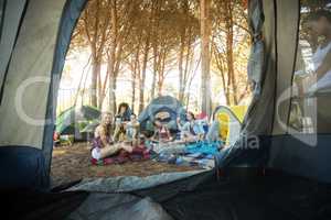 Happy young woman sitting together at campsite