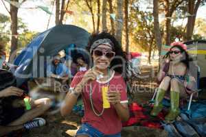 Smiling young woman holding bubble wand at campsite