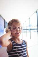 Elementary girl with eyes closed listening music through headphones