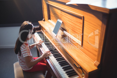 High angle view of concentrated girl practicing piano