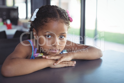 Girl leaning on desk in school