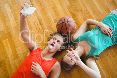 Overhead view of friends taking selfie while lying on floor