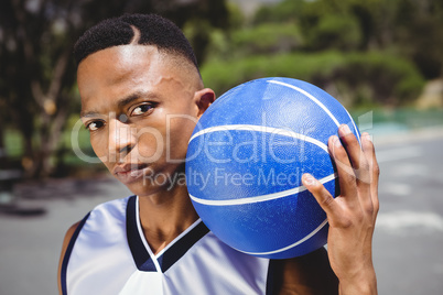 Close up portrait of male teenager with basketball