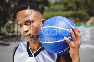 Close up portrait of male teenager with basketball