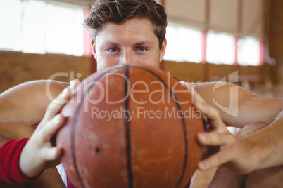 Close up portrait of male basketball player holding ball