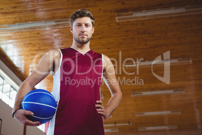 Portrait of male basketball player with hand on hip