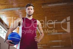 Portrait of male basketball player with hand on hip