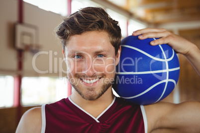 Close up portrait of smiling basketball player holding ball