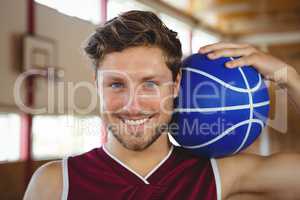 Close up portrait of smiling basketball player holding ball