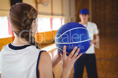 Female basketball player practicing with male coach
