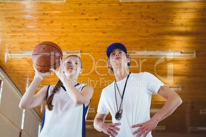Low angle view of male coach advising female basketball player