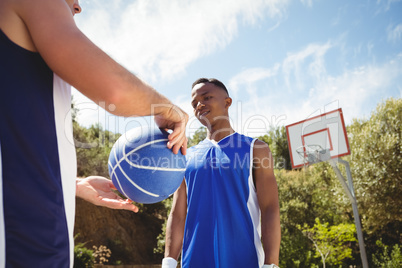 Man showing basketball to friend