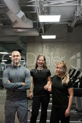 Portrait of smiling friends standing at gym