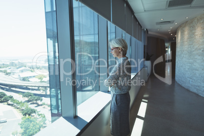 Thoughtful businesswoman standing by window