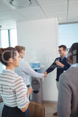 Happy business colleagues shaking hands at office