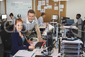 Portrait of young business colleagues working on computer at office