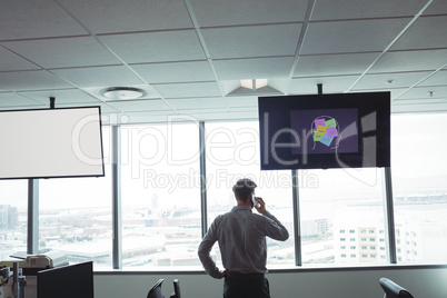 Rear view of businessman taking on mobile phone at office