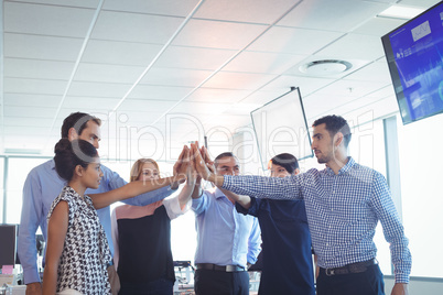 Business colleagues putting their hands together