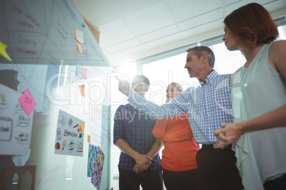 Low angle view of business people discussing over whiteboard at office