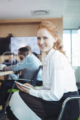 Portrait of businesswoman holding digital tablet at office