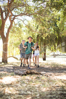 Friends with backpack walking on field