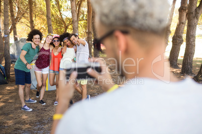 Rear view of man photographing friends