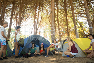 Friends by tents at campsite