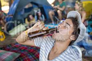 Young man drinking beer from bottle