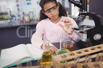 Concentrated elementary student examining sample at laboratory