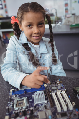 Portrait of elementary girl assembling circuit board