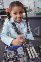 Portrait of elementary girl assembling circuit board