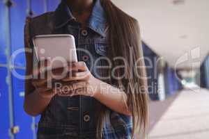 Elementary student using smartphone in corridor