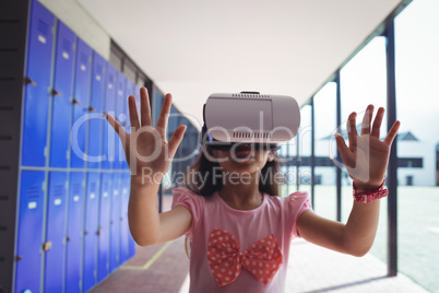 Schoolgirl anticipating while using virtual reality glasses in corridor