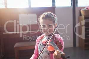 Portrait of smiling girl student rehearsing violin