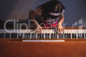 Overhead view of elementary girl playing piano in classroom