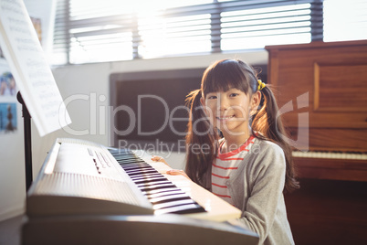 Portrait of smiling girl practicing piano